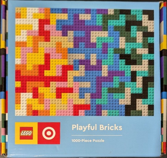 Abstract mosaic pattern of interlocking plastic construction brick studs in warm and cool tones.