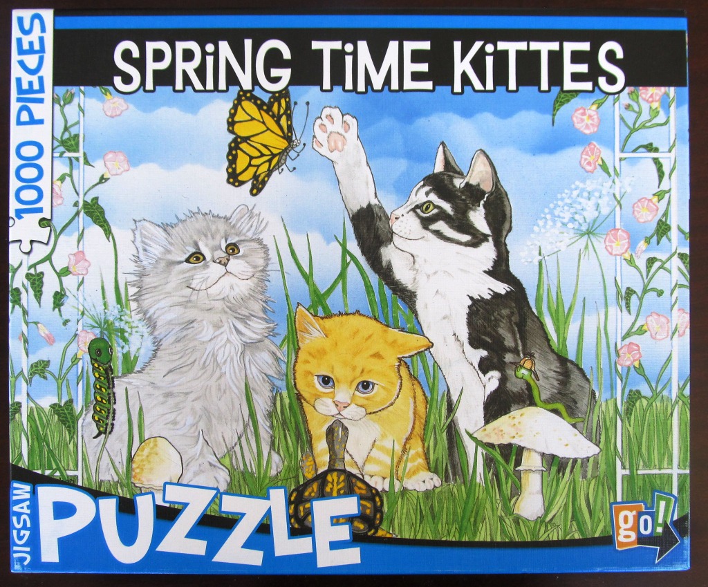 Three kittens playing in a garden with a butterfly, a turtle, and a caterpillar.