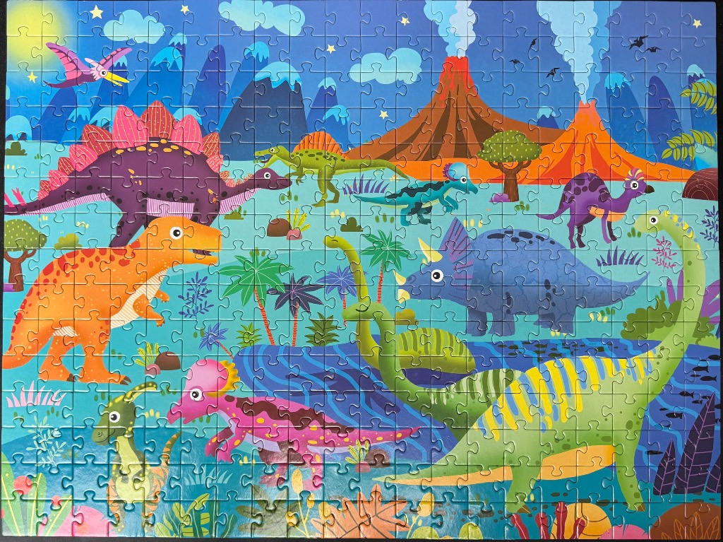 Cartoon illustration of various colorful dinosaurs in a prehistoric landscape with volcanoes and mountains.
