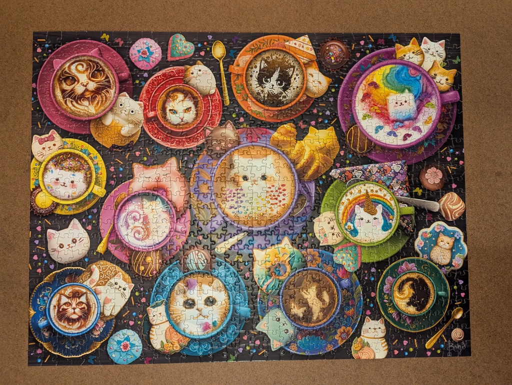 A whimsical illustration of many cats depicted as latte art in colorful teacups surrounded by sweets on a dark background.