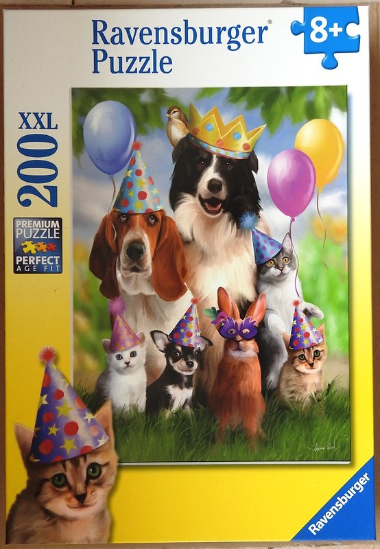 A group of animals including a dog, cat, and rabbit wearing party hats and a mask in a grassy outdoor setting.