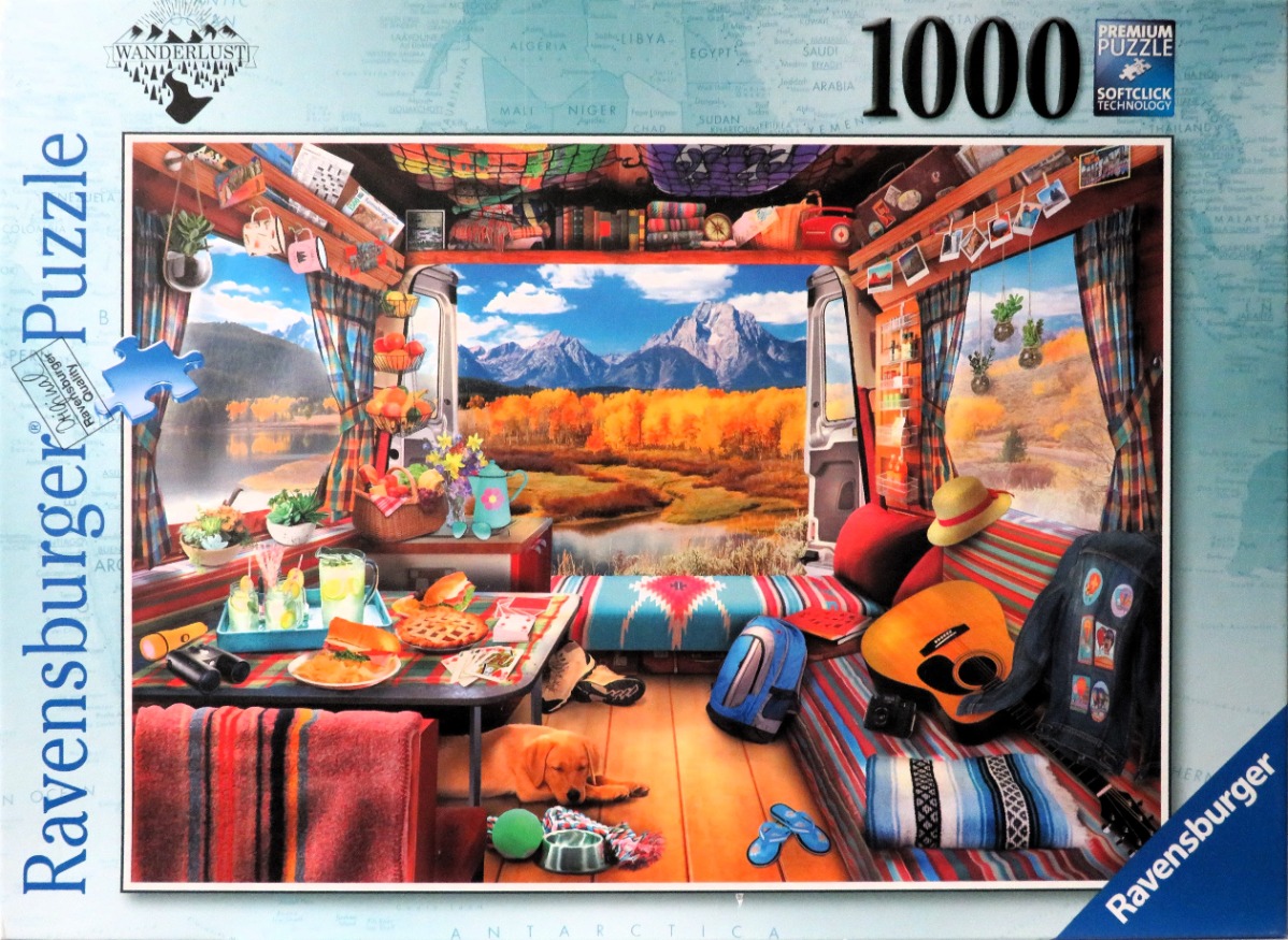 Interior view of a cozy camper van looking out at a mountain range during autumn.