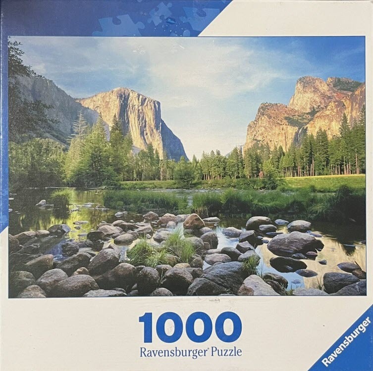 Scenic photograph of Yosemite Valley with granite cliffs, a pine forest, and a rocky river in the foreground.