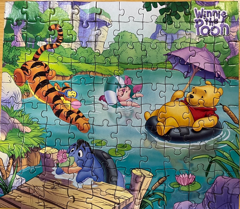 Winnie the Pooh and friends playing in a pond on a summer day