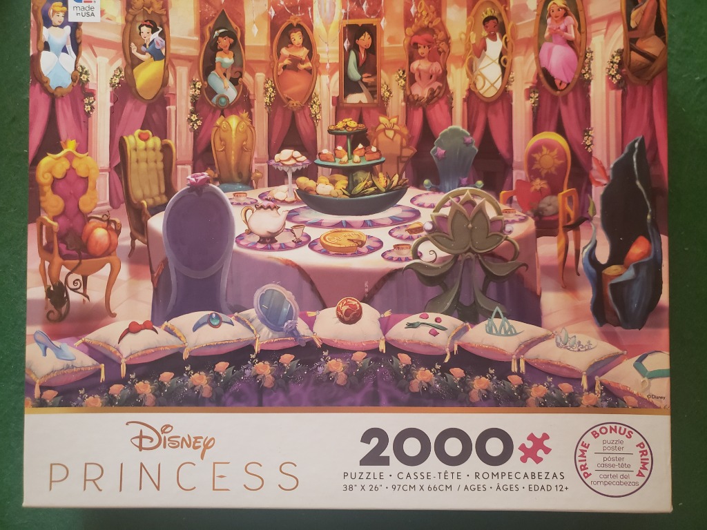 A whimsical banquet table decorated with iconic objects and portraits from various Disney Princess films.
