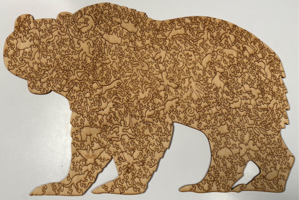 A silhouette of a standing bear constructed from intricate, interlocking wooden shapes.