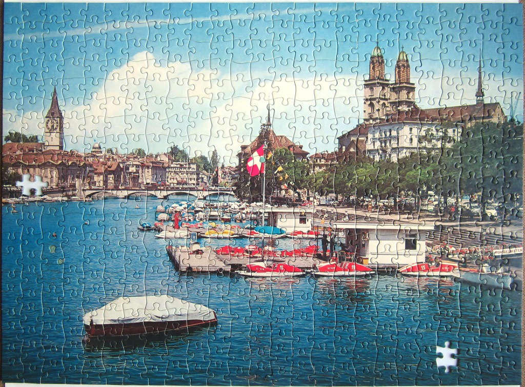 Scenic view of Zurich city skyline and the Limmat River with pedal boats.