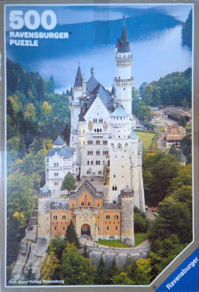 Neuschwanstein Castle surrounded by lush forest and a deep blue lake