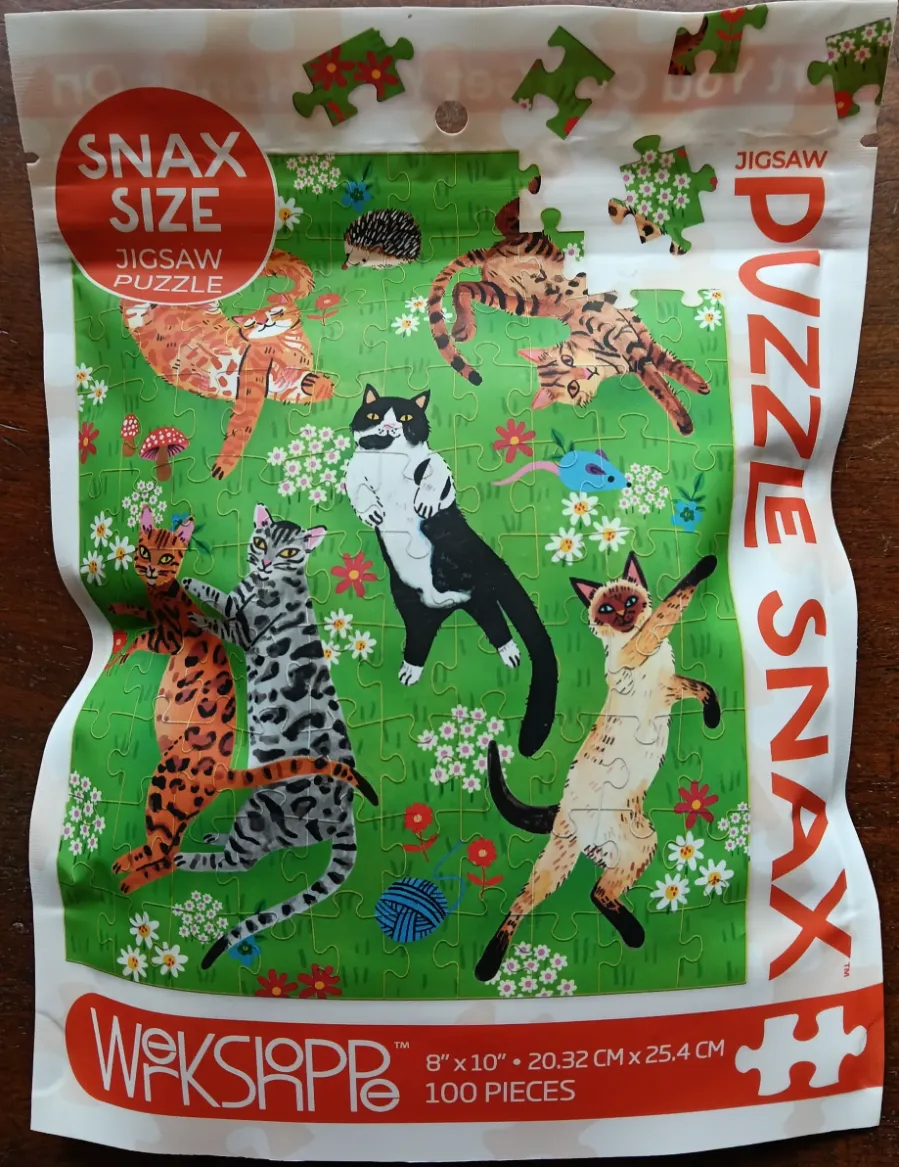 A whimsical illustration of seven diverse cats playing in a meadow with flowers and a small hedgehog.