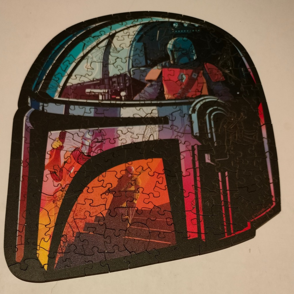 Shaped illustration of Boba Fett’s helmet featuring scenes from his life within the visor and panels.