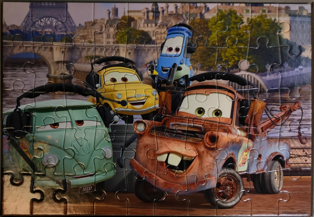Animated characters Mater, Fillmore, Luigi, and Guido in front of the Eiffel Tower in Paris.