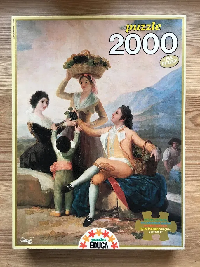 Classical oil painting of a Spanish group in 18th-century attire harvesting grapes in a mountainous landscape.