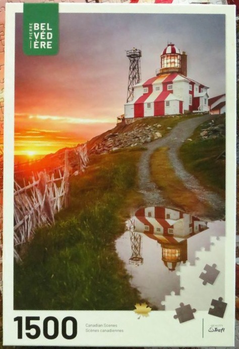 A lighthouse with bold red and white stripes stands on a coastal cliff at sunset.
