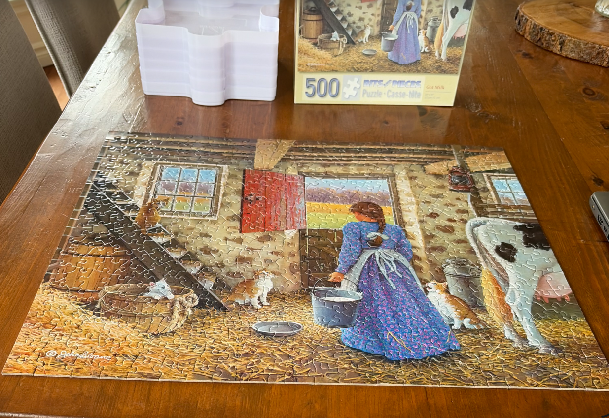 A pastoral illustration of a woman in a blue dress milking a cow in a barn filled with kittens.