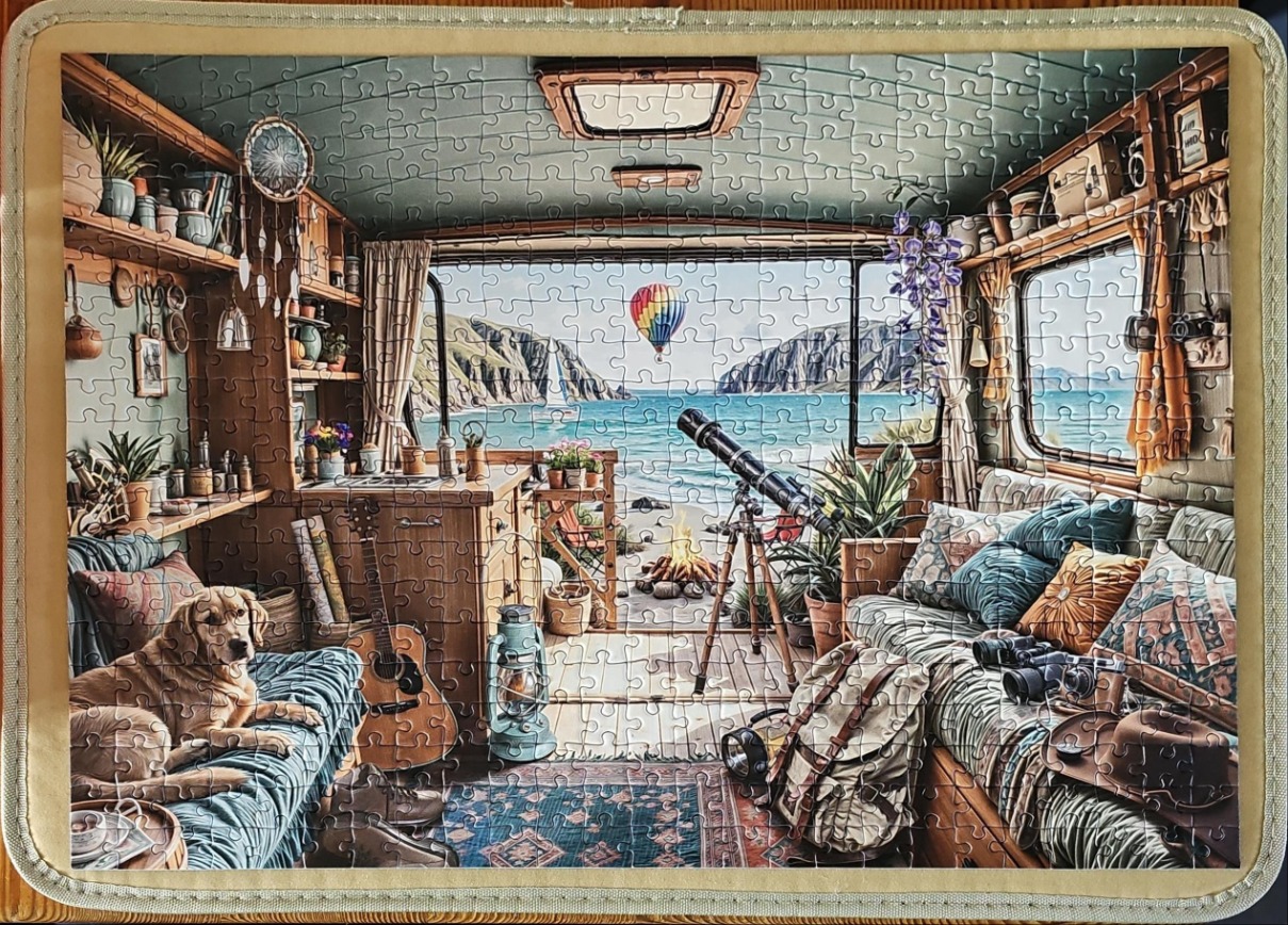 Cozy interior of a retro camper van overlooking a beach with a dog and telescope