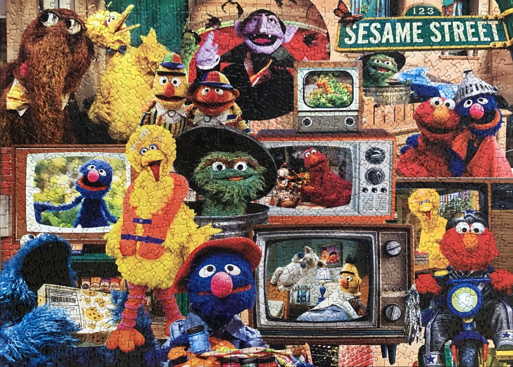 A colourful collage of various Sesame Street characters and vintage television sets.