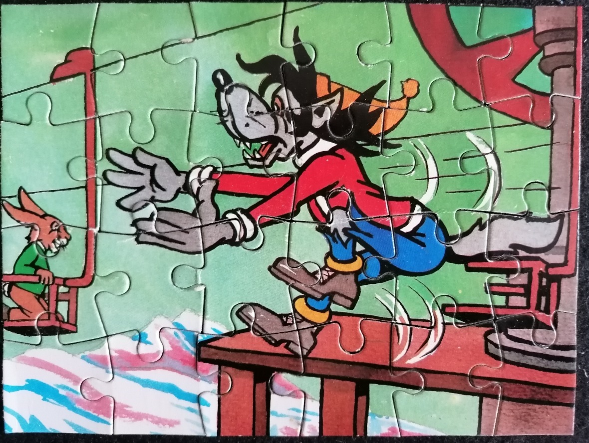 Cartoon scene featuring a wolf in a red jacket chasing a rabbit in a ski lift carriage over a snowy landscape.