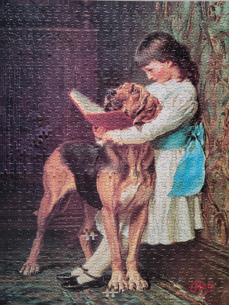 A young girl in a white dress reading a book to a large bloodhound dog.