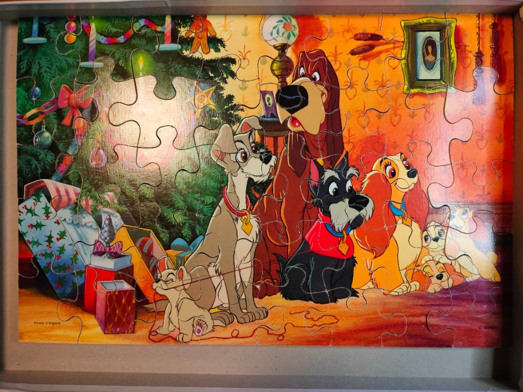Cartoon scene featuring the dogs from Lady and the Tramp gathered in a cozy living room during Christmas.