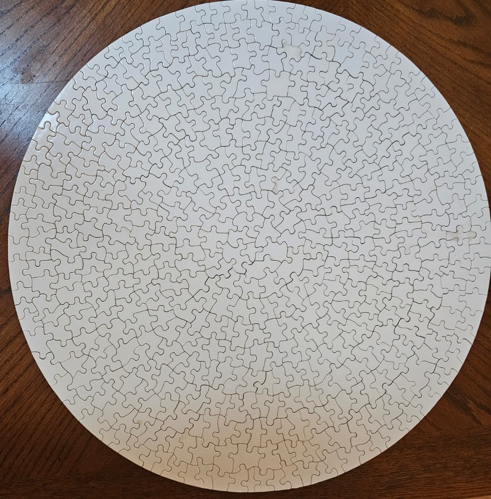 A solid white circle centered on a dark brown wooden surface.