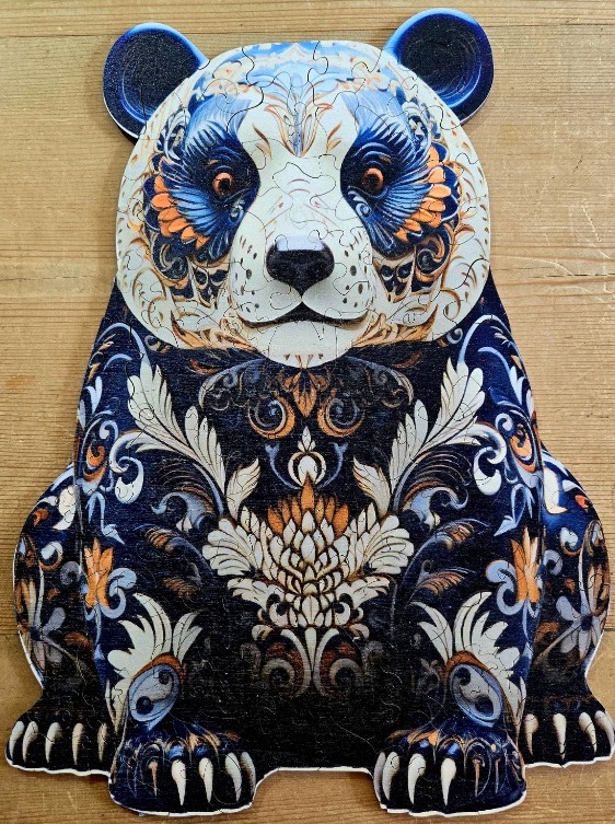 Artistic illustration of a panda sitting and decorated with intricate floral and paisley patterns in blue, gold, and white.