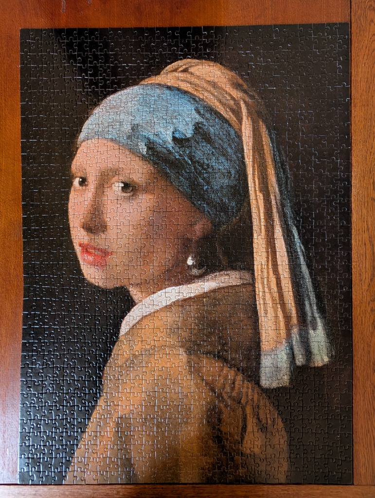A portrait of a young woman wearing a blue headscarf and a large pearl earring, modeled after Girl with a Pearl Earring.