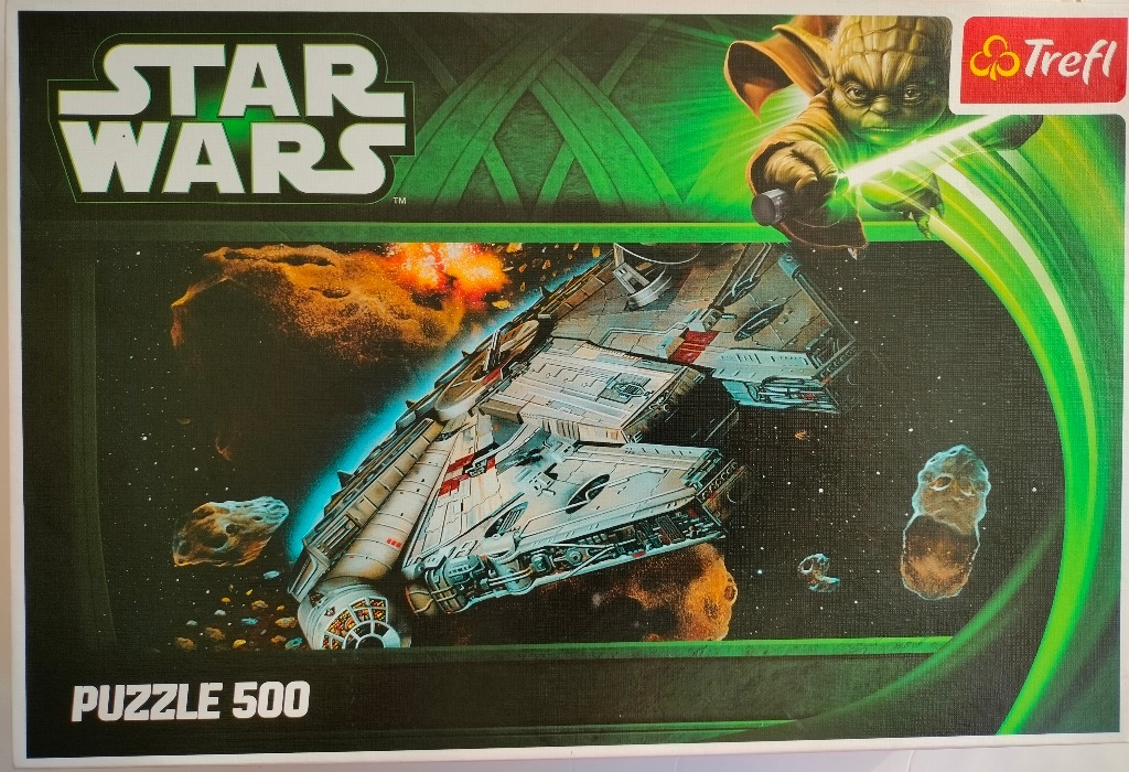 Yoda wielding a lightsaber above the Millennium Falcon flying through an asteroid field.