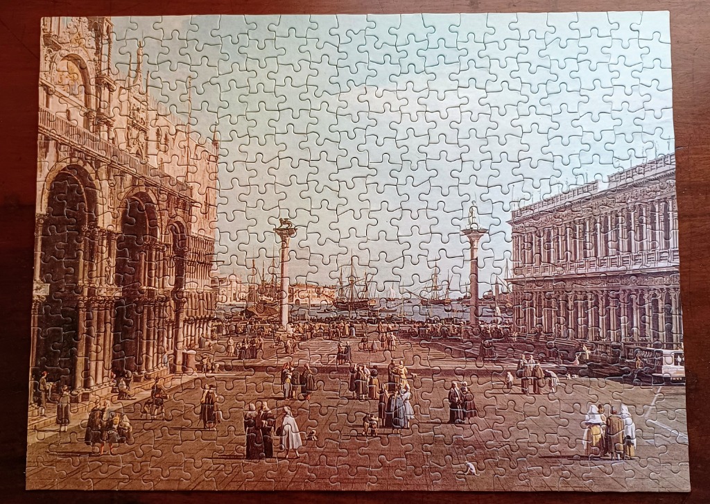 A classic painting of a busy Venetian piazza with grand architecture and ships in the background.
