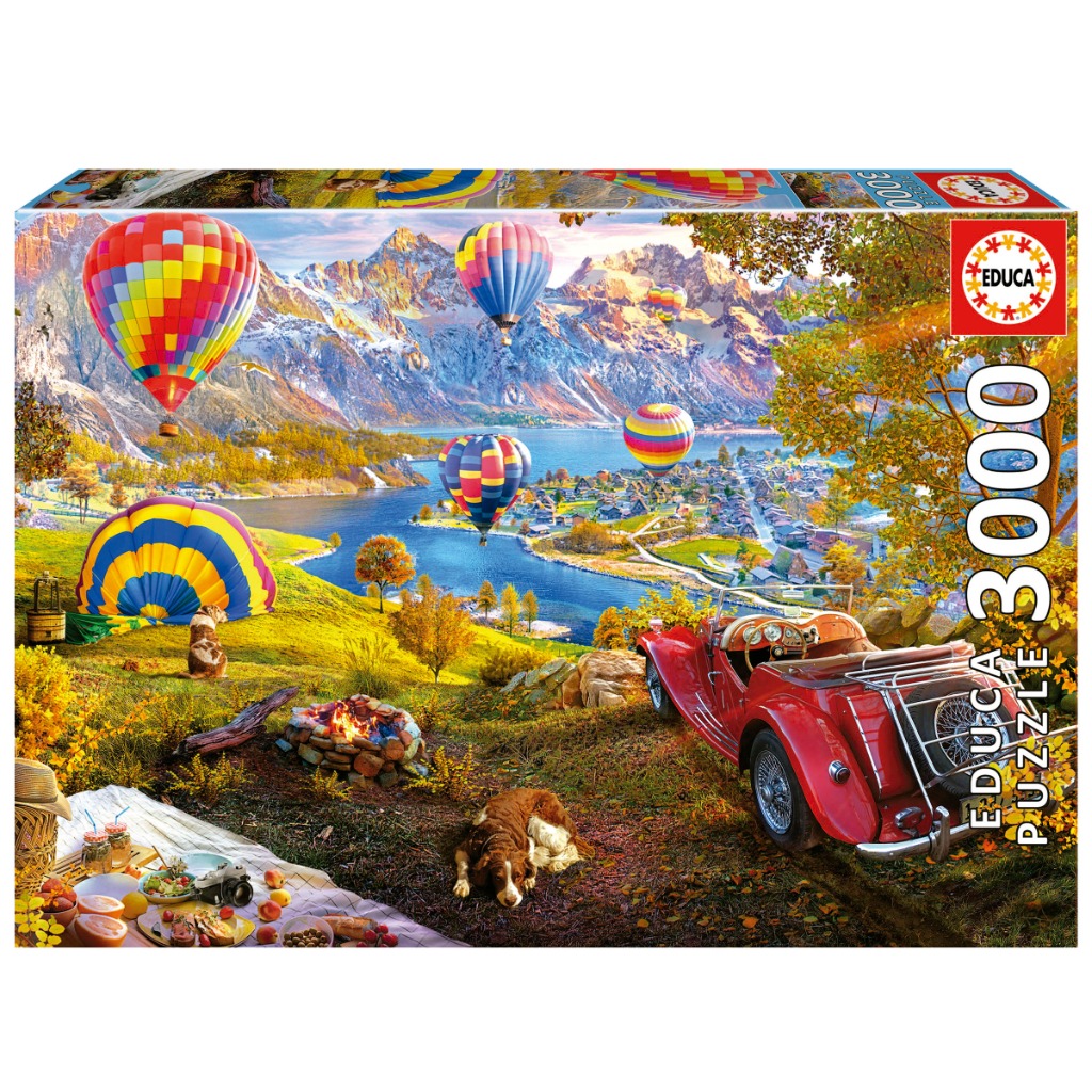 A scenic landscape featuring a red vintage car, a picnic, a dog, and hot air balloons over a lake and mountains.