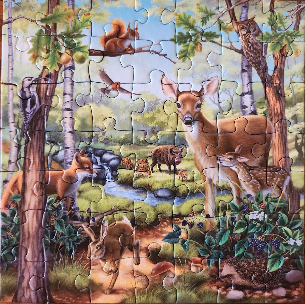 A lush forest scene featuring a deer, a fox, a hedgehog, and other woodland wildlife in a detailed painting.