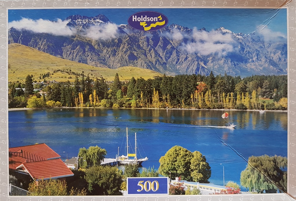 A panoramic photograph of a lake at the base of the Remarkables mountain range in New Zealand.