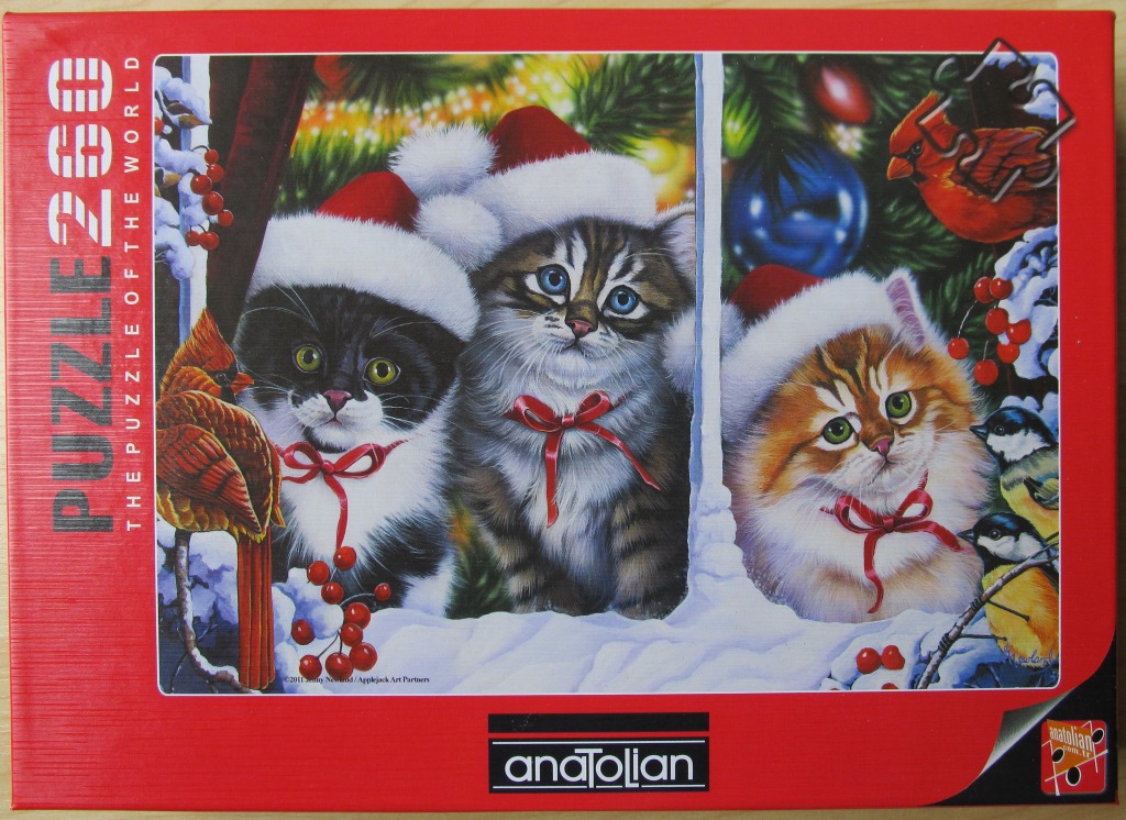 Three kittens wearing Santa hats peeking through a window during Christmas