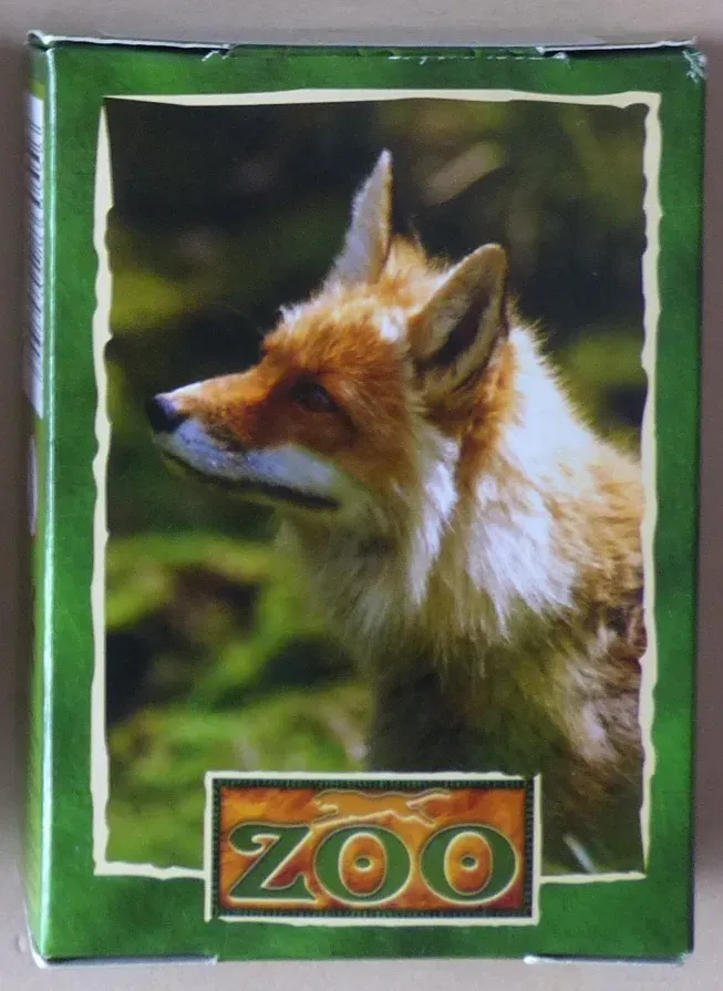 Close-up portrait of a red fox looking to the left against a blurred green forest background.