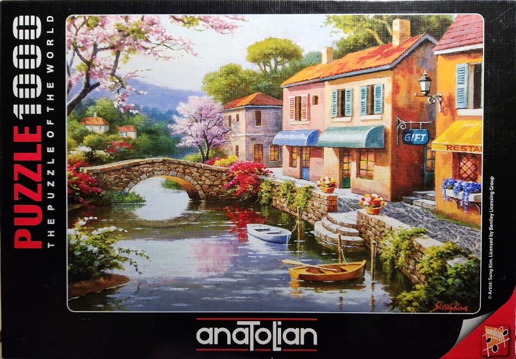 A scenic oil painting of a quaint European village canal with a stone bridge, boats, and flowering trees.