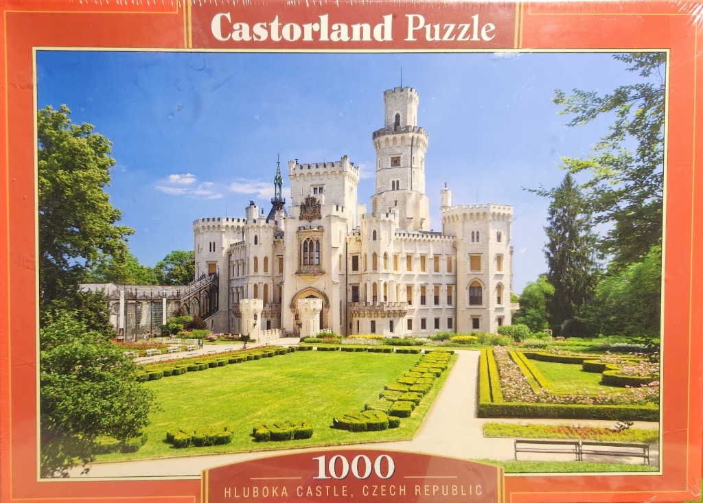 Photograph of Hluboka Castle in the Czech Republic featuring a white castle with towers and manicured gardens.