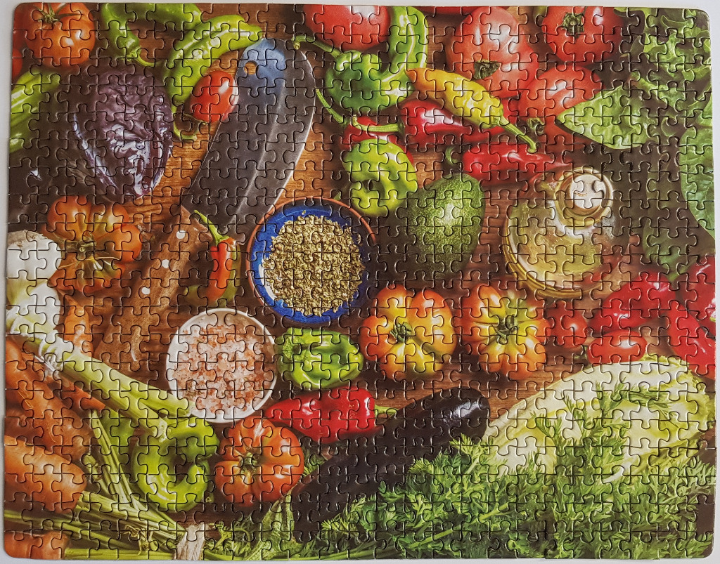 A top-down view of fresh vegetables, a cleaver, and spices on a rustic wooden table.