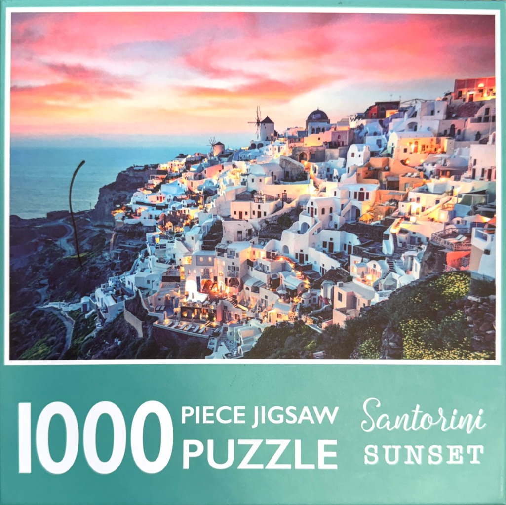 A photograph of Oia, Santorini, featuring white buildings clinging to a cliffside at sunset with a vibrant pink sky.