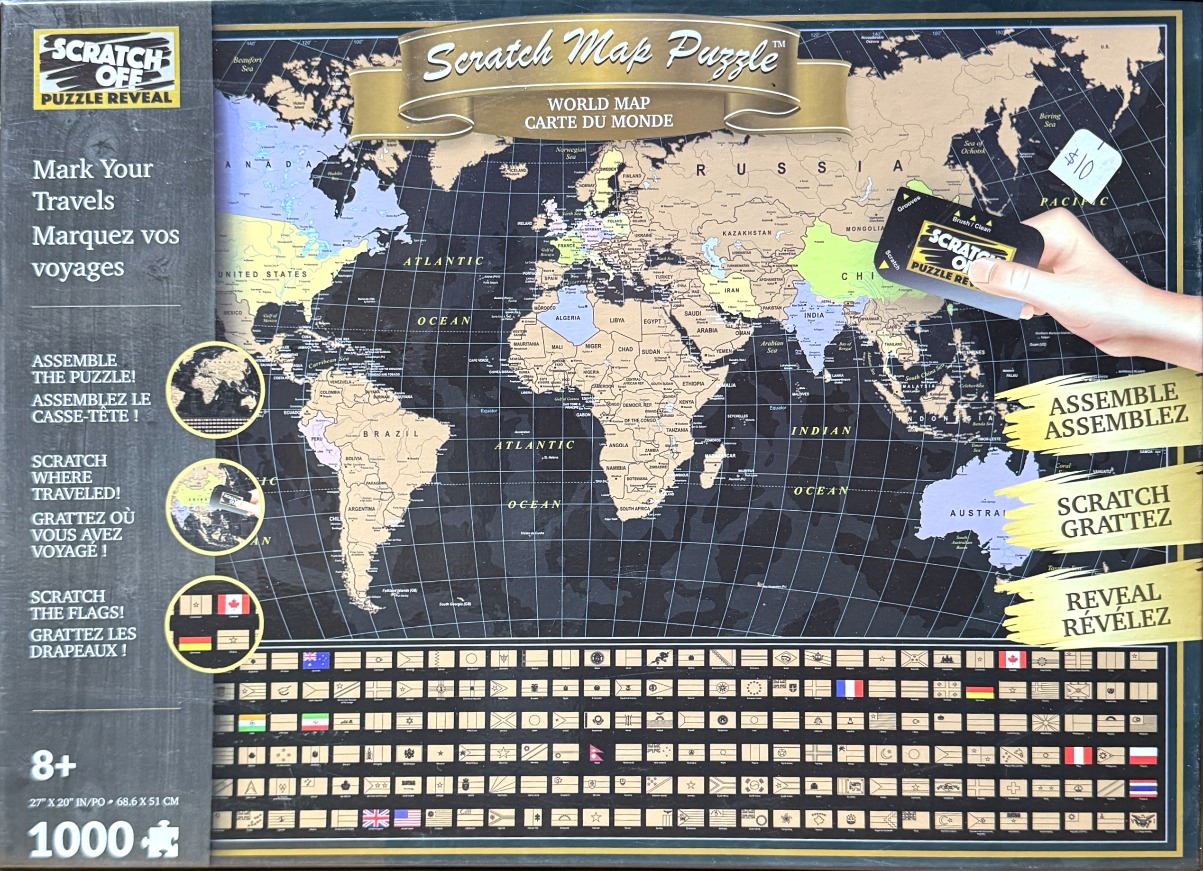A scratch-off world map design with a black background, beige continents, and colorful flags at the bottom.