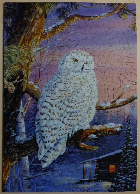 A snowy owl perched on a pine tree branch in a winter forest at twilight.