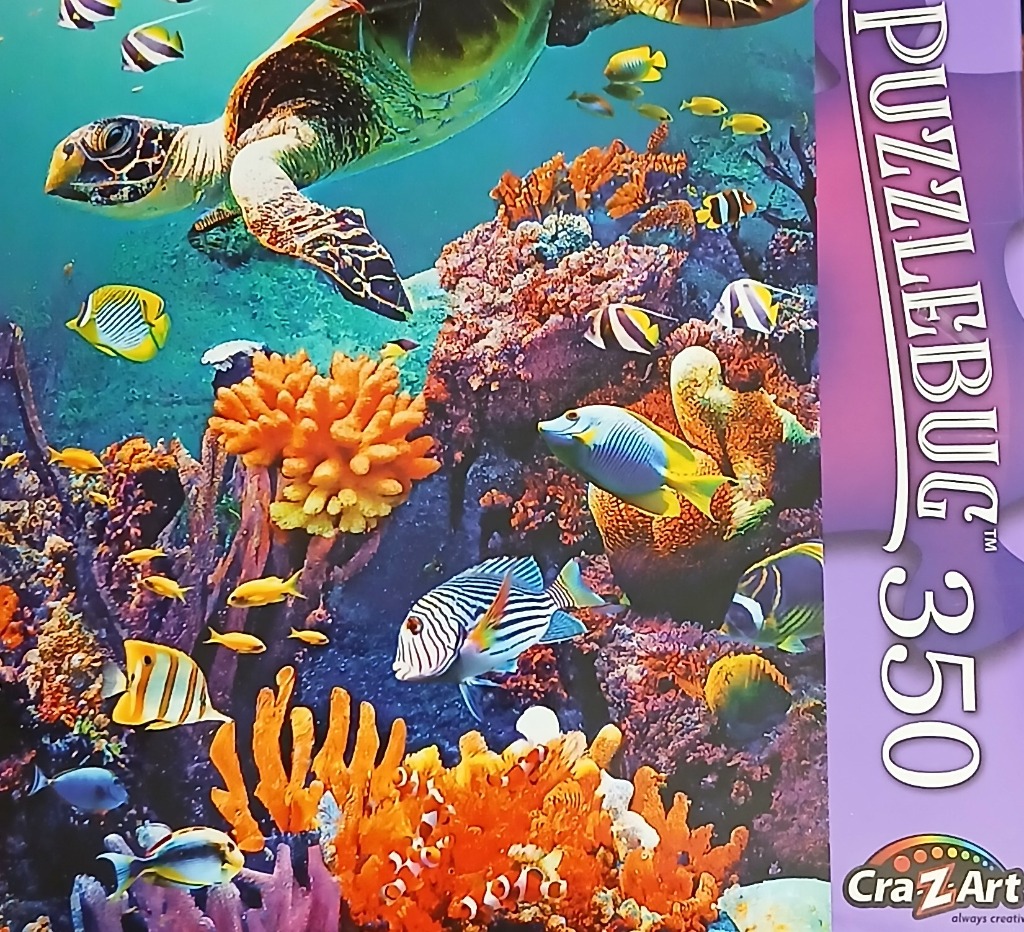 A sea turtle swims above a vibrant coral reef teeming with colorful tropical fish.