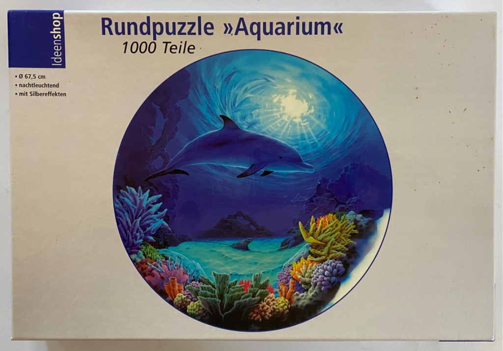 An underwater scene with a dolphin swimming above a colorful coral reef, framed within a circle.