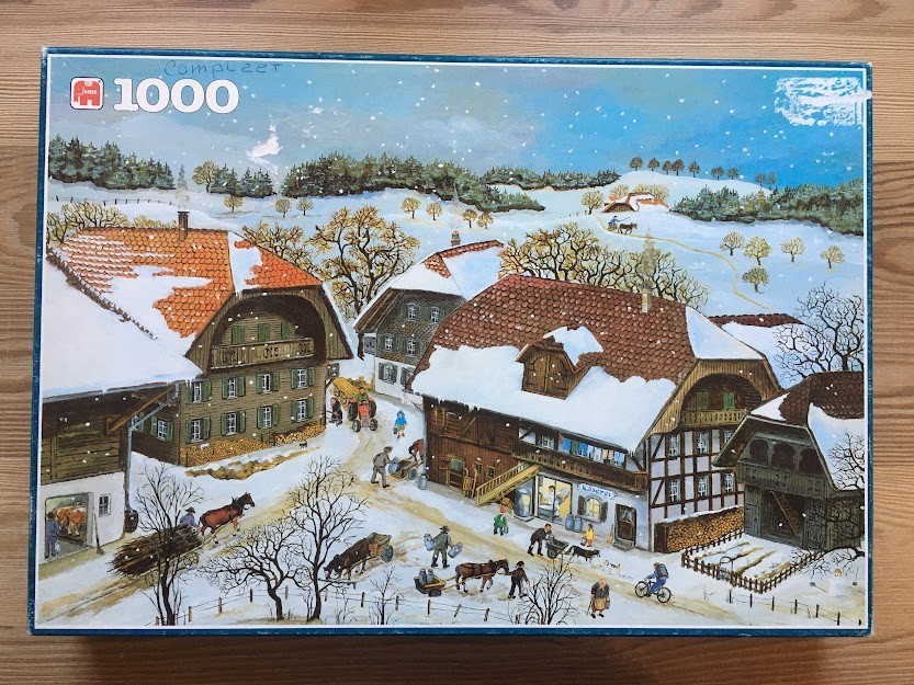 Illustration of a snowy Alpine village with people and horses performing daily chores in winter.