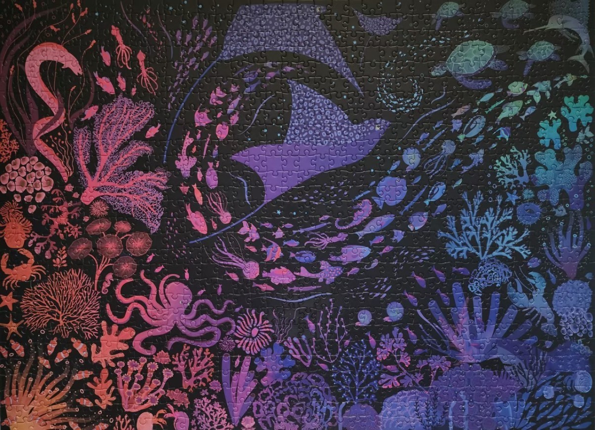 A neon-styled underwater scene with marine life including an octopus, a stingray, and coral against a black background.