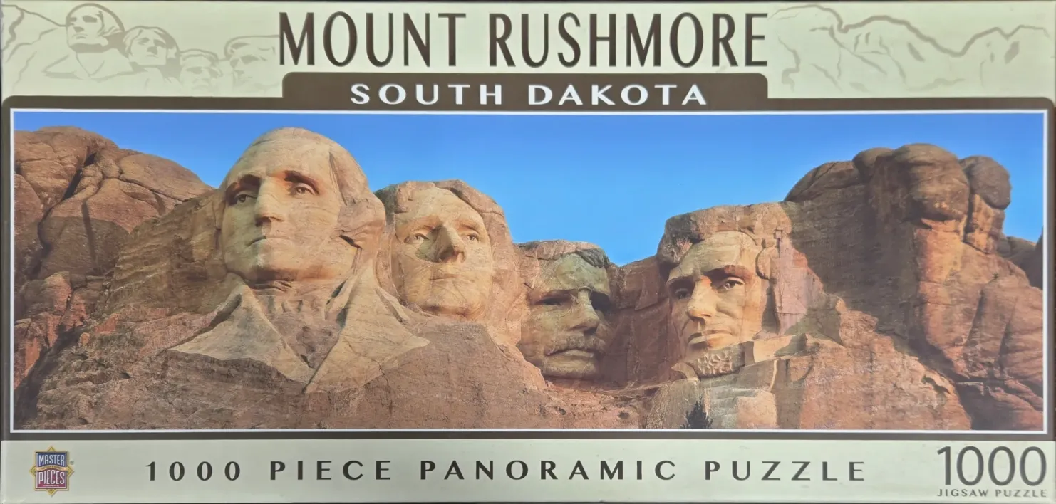 Panoramic photograph of the Mount Rushmore monument under a clear blue sky.