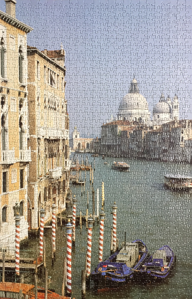 View of the Grand Canal in Venice featuring historic architecture and moored blue boats.