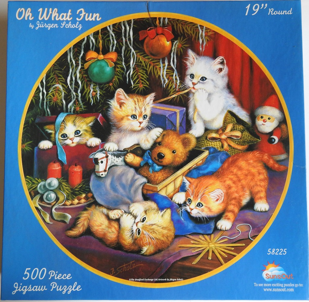 A group of fluffy kittens playing with Christmas decorations and toys under a tree.