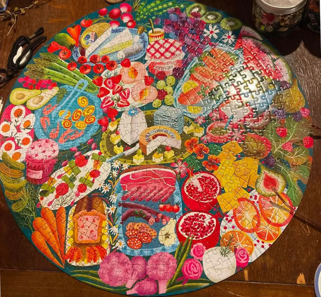 A round illustration filled with an abundance of colorful fresh fruits, vegetables, cheeses, and deli meats.