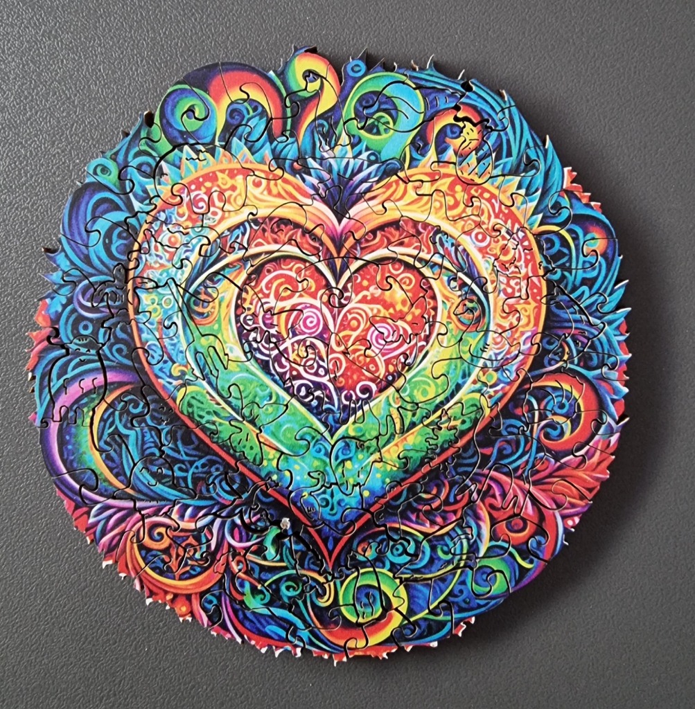 A psychedelic, circular illustration of a vibrant, multi-layered heart design featuring intricate floral and animal patterns.