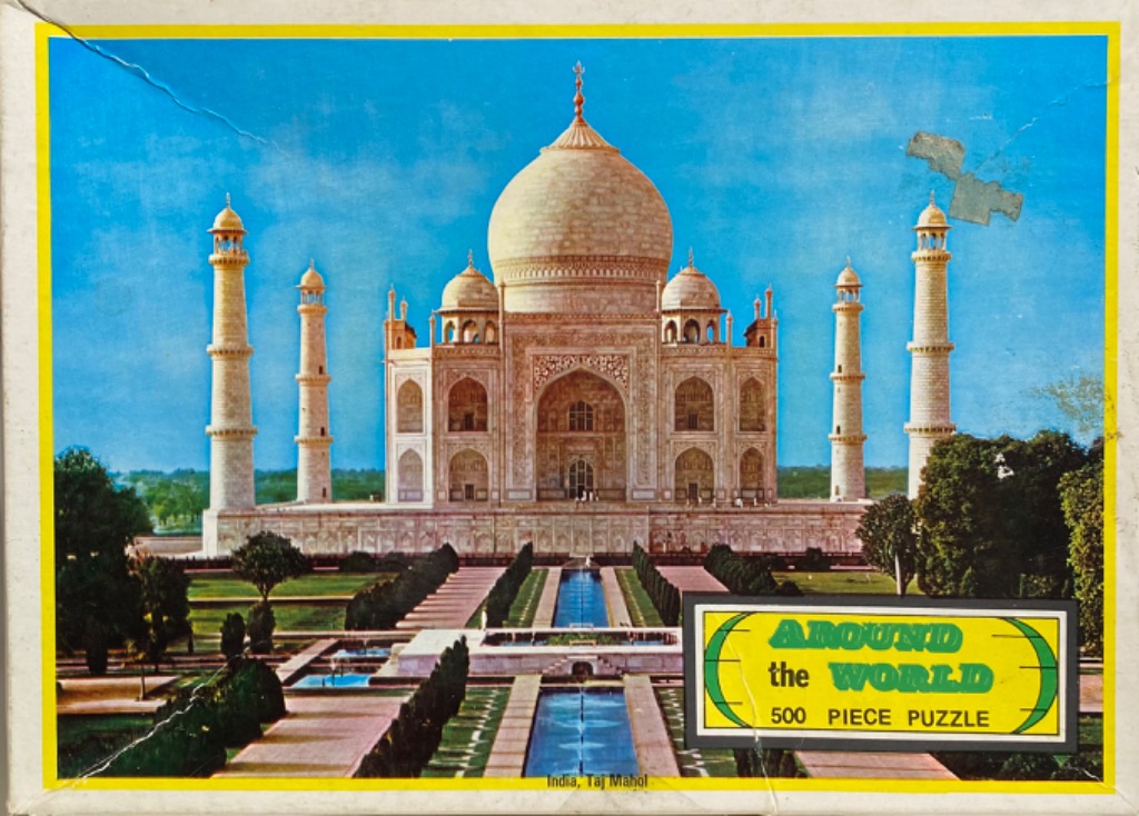 The Taj Mahal centered under a vibrant blue sky, surrounded by gardens and reflecting pools.