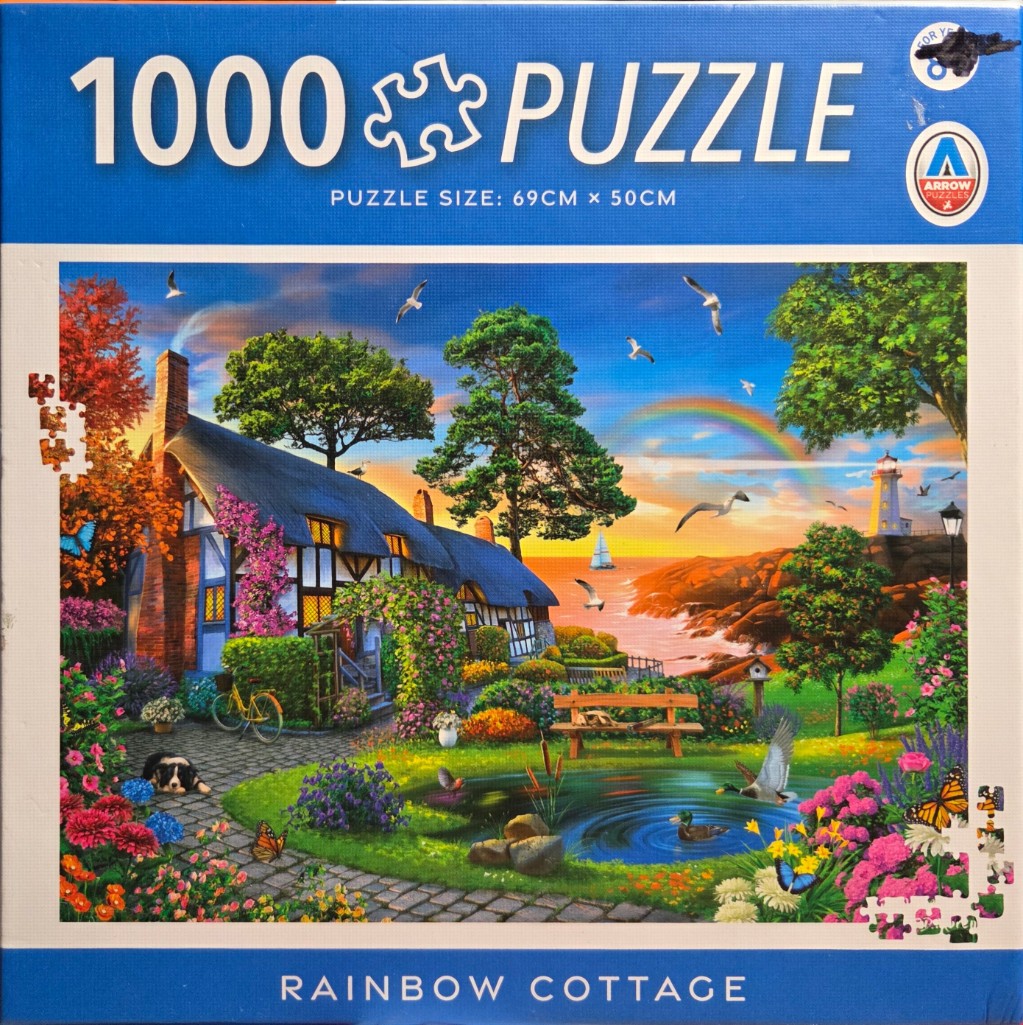 A charming thatched cottage with a garden pond, rainbow, and lighthouse at sunset.